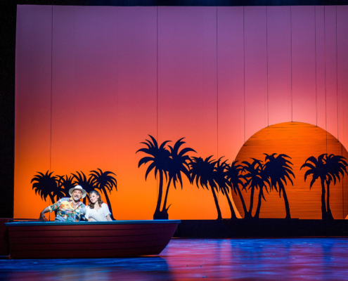 Bühnenbild Sonnenuntergang. Links Boot mit zwei Darstellenden.