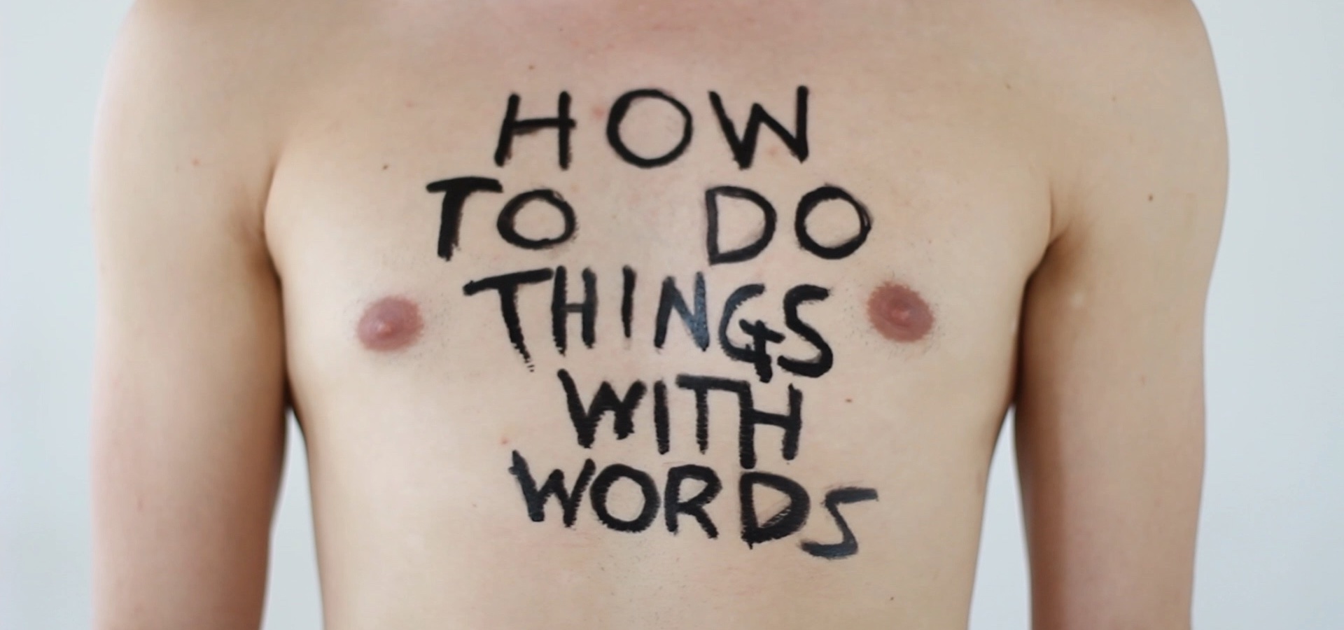 Foto auf Männerbrust geschrieben: How to do things with words.